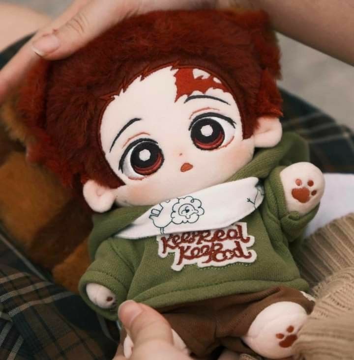 a person holding a small doll with blood on it