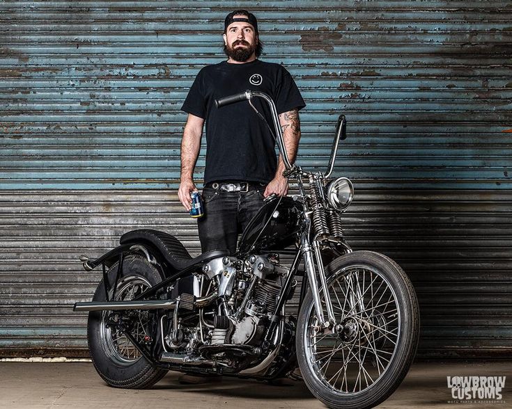 a man standing next to a motorcycle in front of a garage door