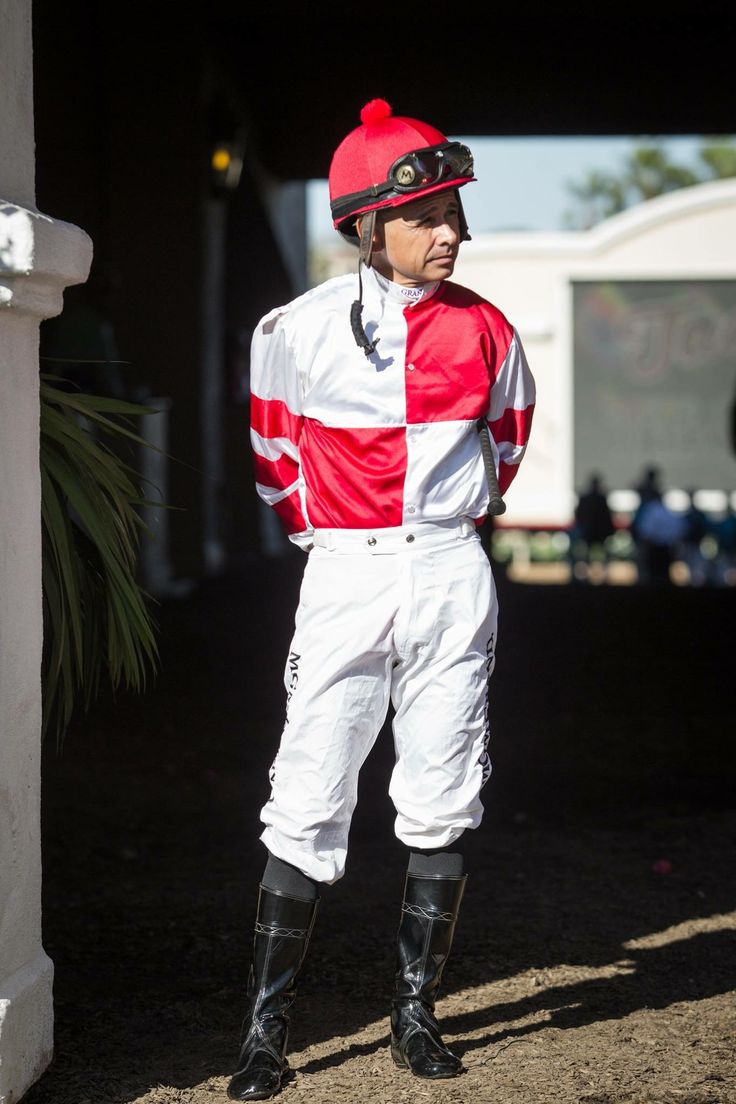 a man wearing a red and white jockey suit