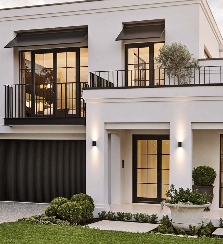 a white two story house with black doors and windows