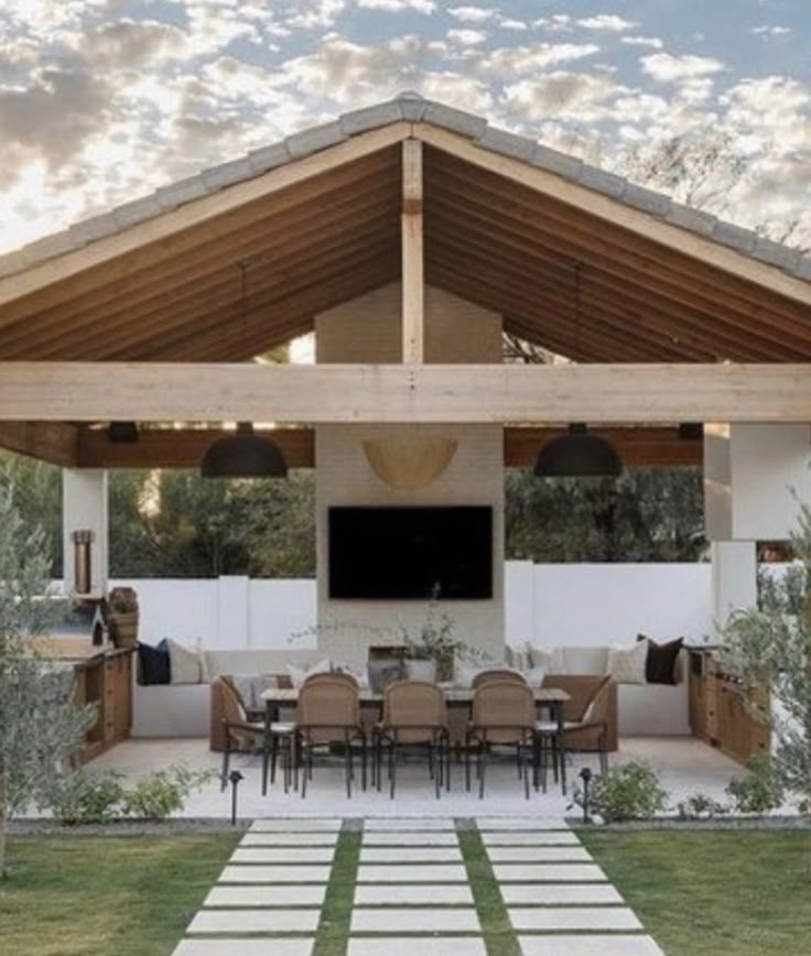 an outdoor kitchen and dining area is shown in the evening sun, with white tiles on the floor