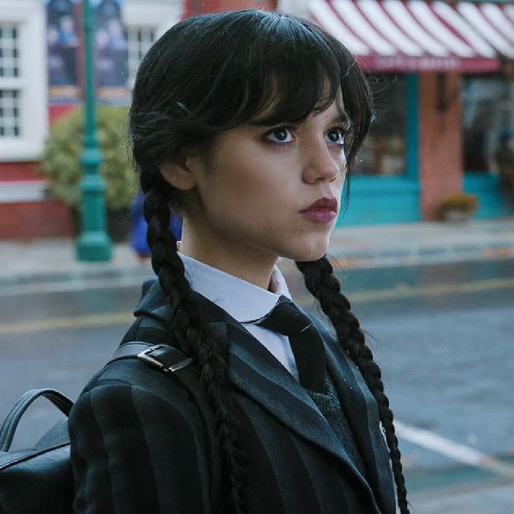 a woman with long braids standing on the street