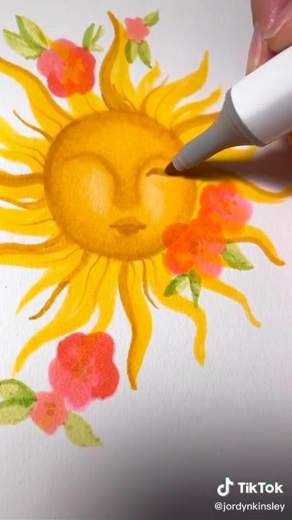 someone is drawing a sun with watercolors on paper