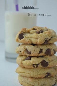 a stack of chocolate chip cookies next to a glass of milk with the caption shh it's a secret