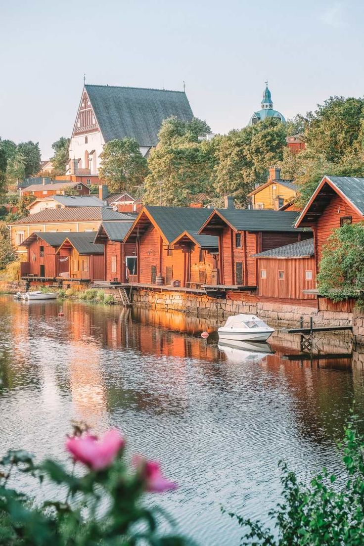 boats are parked on the water in front of wooden buildings