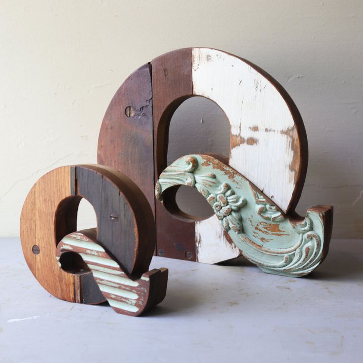 two wooden letters with carved animals on them