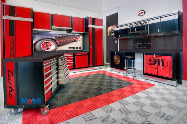 a garage with red and black cabinets, checkered flooring, and an automobile logo on the wall