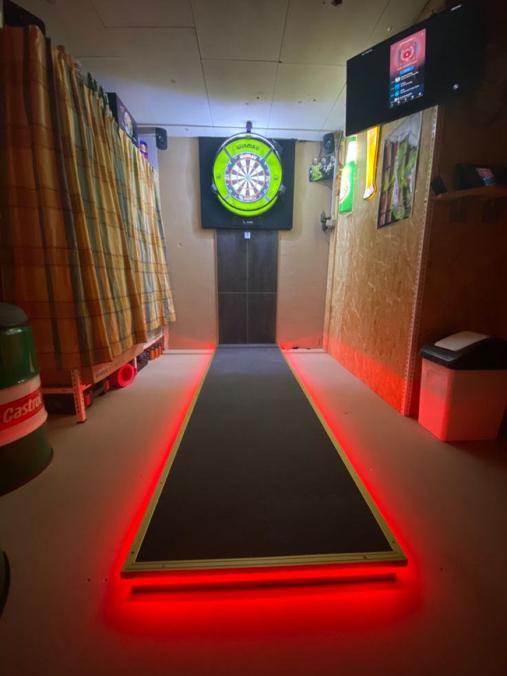 a room with a dart board on the floor and neon lights in the corner around it