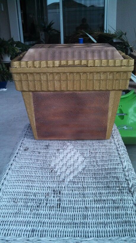 a large brown and tan cooler sitting on top of a rug next to a green box