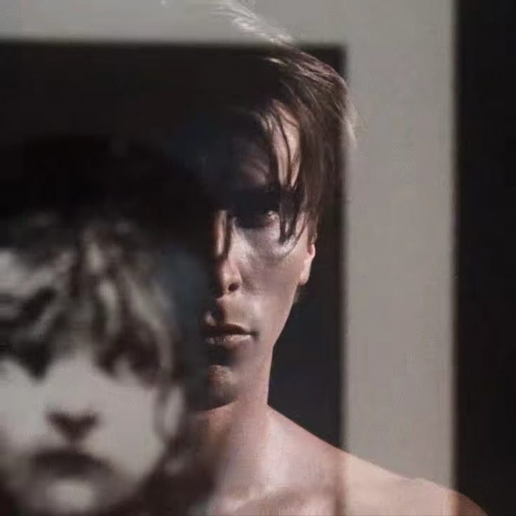 a blurry image of a man's face in front of a mirror with his reflection