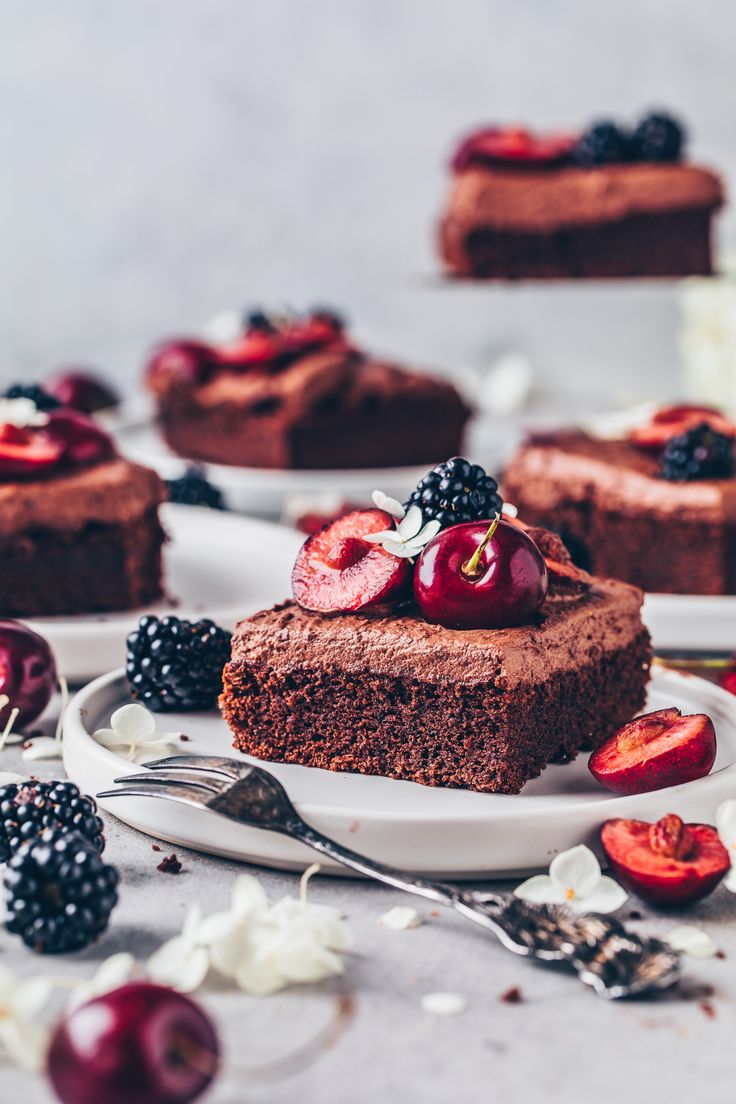 slices of chocolate cake with cherries and blackberries