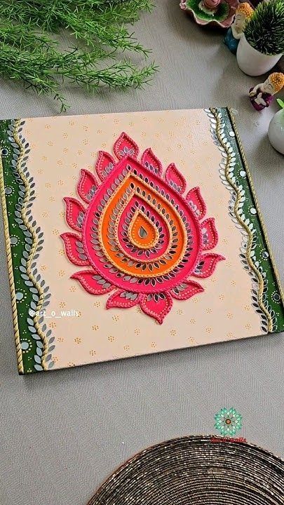 an intricately decorated card on a table next to some potted plants and other decorations