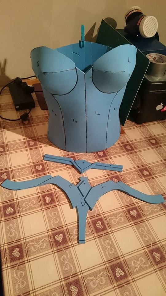 the paper is cut out to look like a corset and scissors are on the table