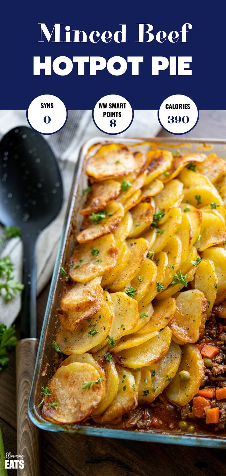 a casserole dish with sliced potatoes and meat in it on a wooden table