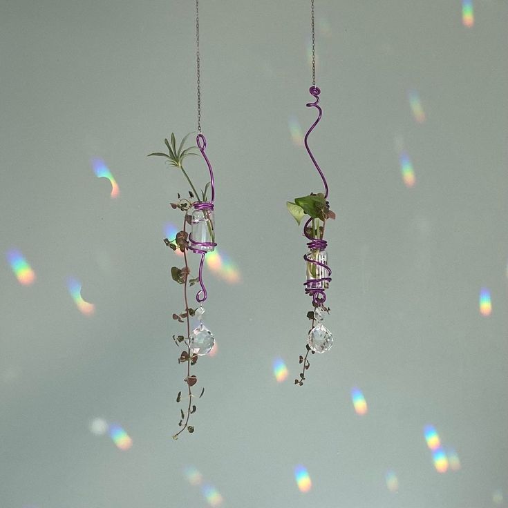 two wind chimes hanging from strings with flowers