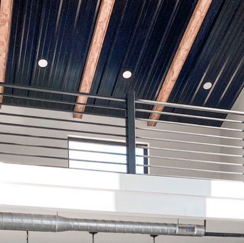 a man riding a skateboard down the side of a metal rail under a roof