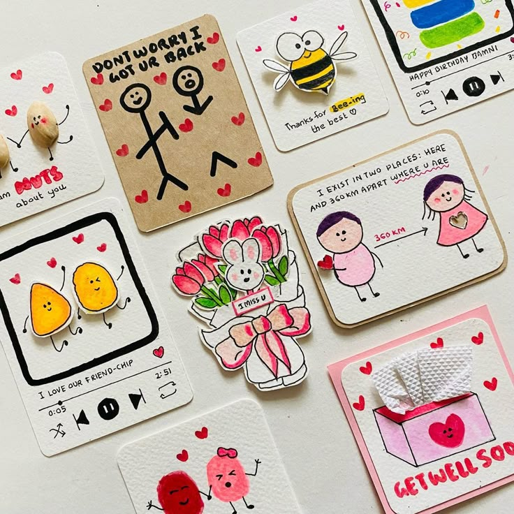 some cards and magnets on a table with hearts, flowers, bees, and other things