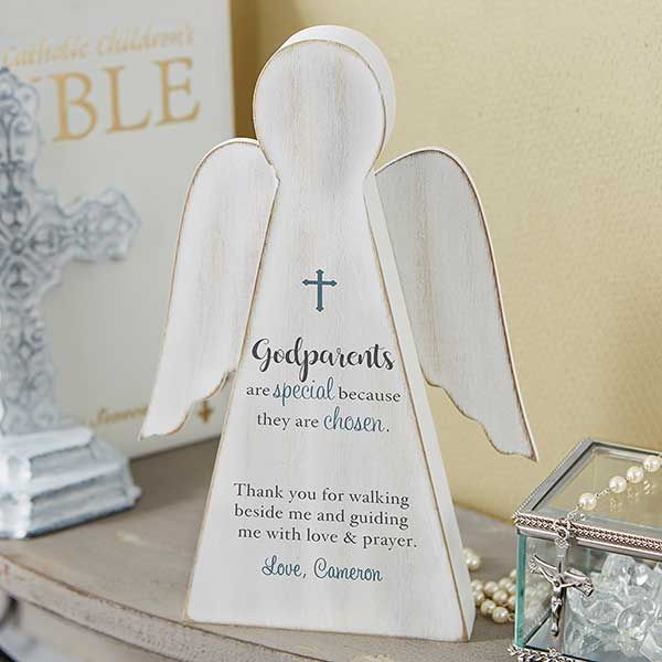 an angel figurine sitting on top of a table next to a box with pearls