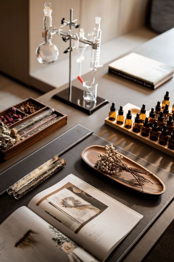 an assortment of perfumes and other items on a table in front of a book