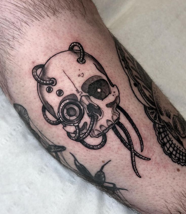 a man's leg with an octopus and skull tattoo on it