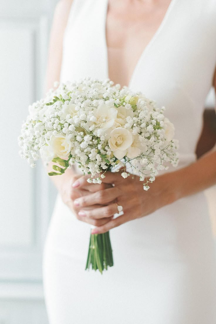 a woman in a white dress holding a bouquet of flowers