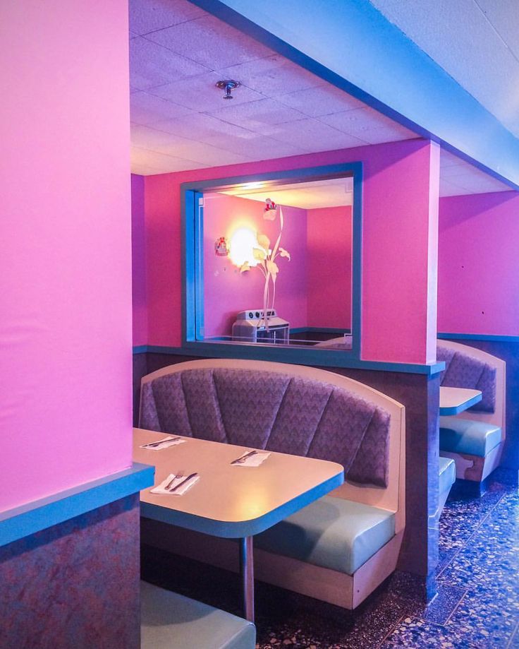 the inside of a restaurant with booths, tables and chairs in front of a mirror