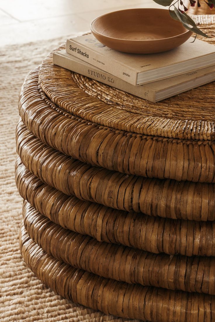 a stack of wicker stacked on top of each other next to a vase with flowers