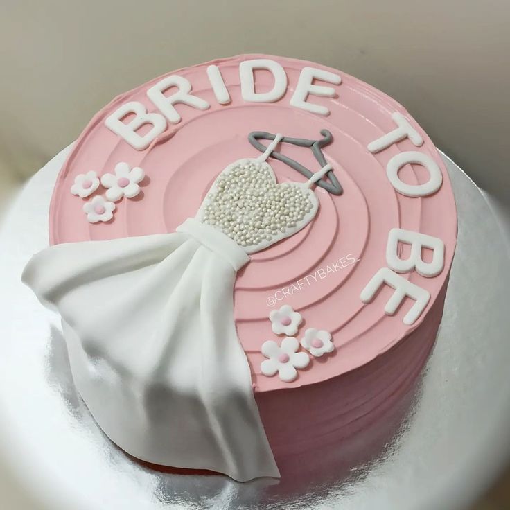 a wedding cake with the bride's dress on top is decorated in pink and white