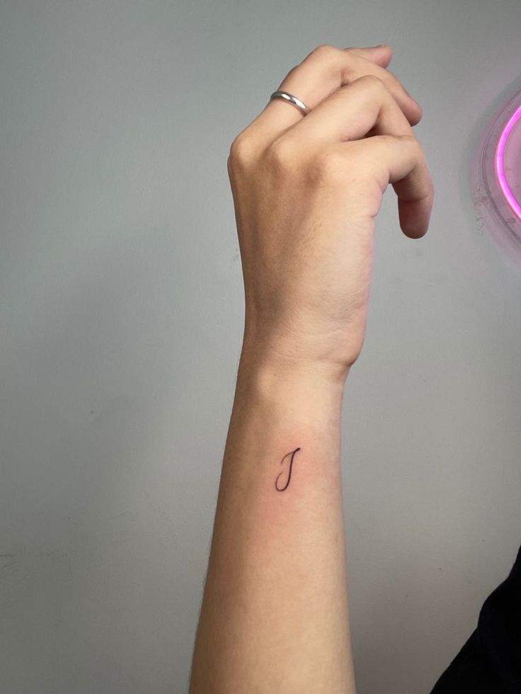 a woman's arm with a small tattoo on the left side of her wrist