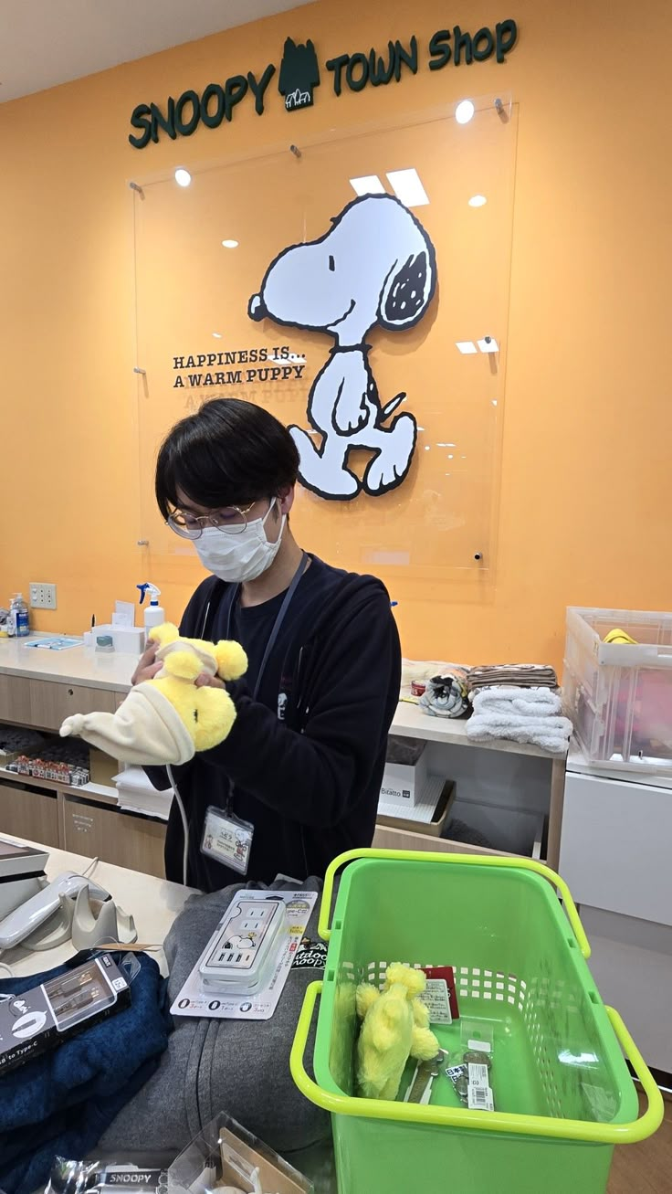 a person wearing a face mask and gloves in front of a store counter with stuffed animals