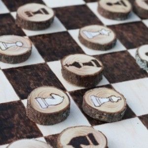 pieces of wood are sitting on top of a checkerboard game board with dices in the middle