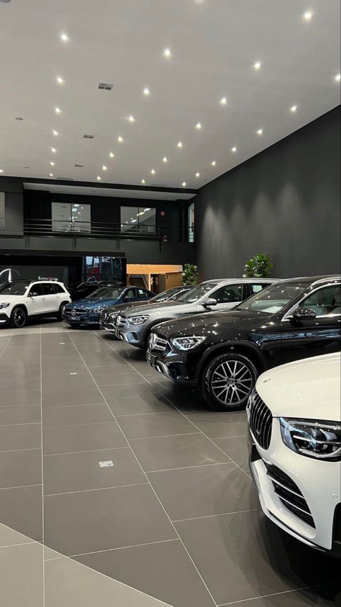 a bunch of cars are parked in a showroom