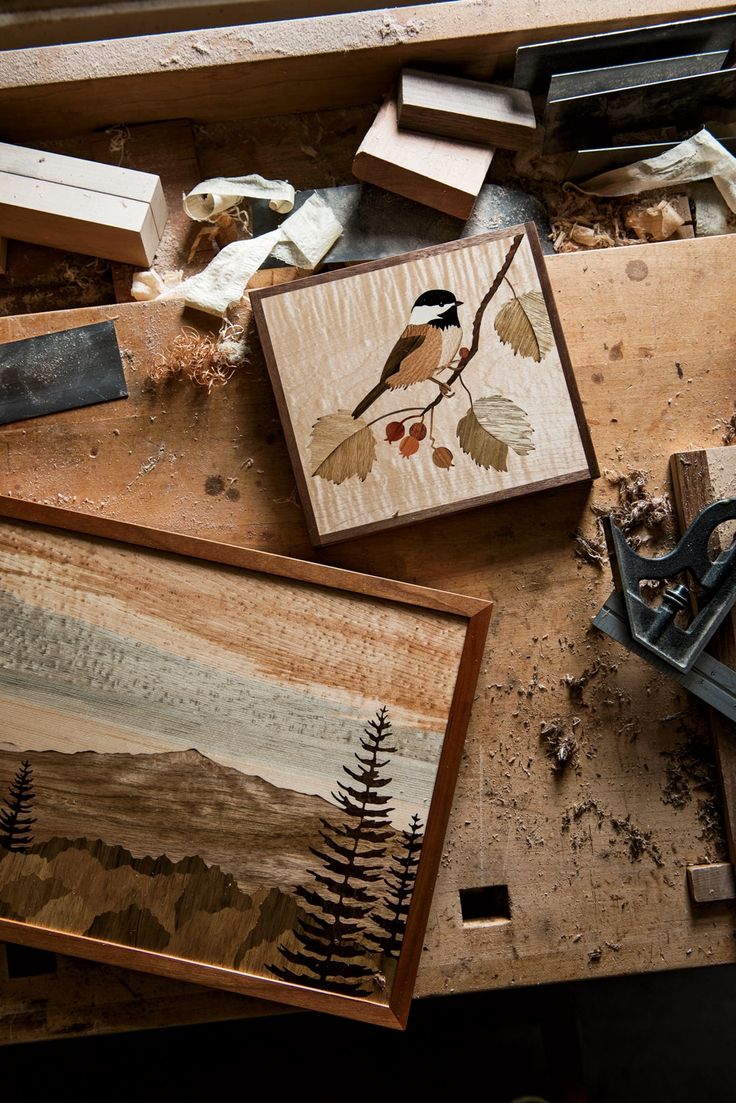 various woodworking tools and paintings on a workbench