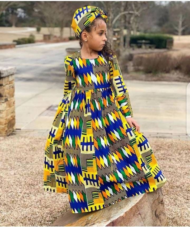 Help your child remember her childhood with this beautiful dress. This is a custom African Girls dress that can be worn for birthdays, photoshoots and other events for babies. Before ordering, please go through the size chart and choose a size for your daughter before checkout. Or you can send her measurement (Chest, Waist, Hip & Dress Length). This is a custom order,it takes 1 week or more during busy sale period to sew and 3-5 business days to ship. If you have any question, please send me a m African Princess Dress, African Birthday Dress, South African Traditional Dresses, Mother Daughter Fashion, Dress African Print, Kente Dress, Ankara Dress Styles, Dresses Flowy, Kente Styles