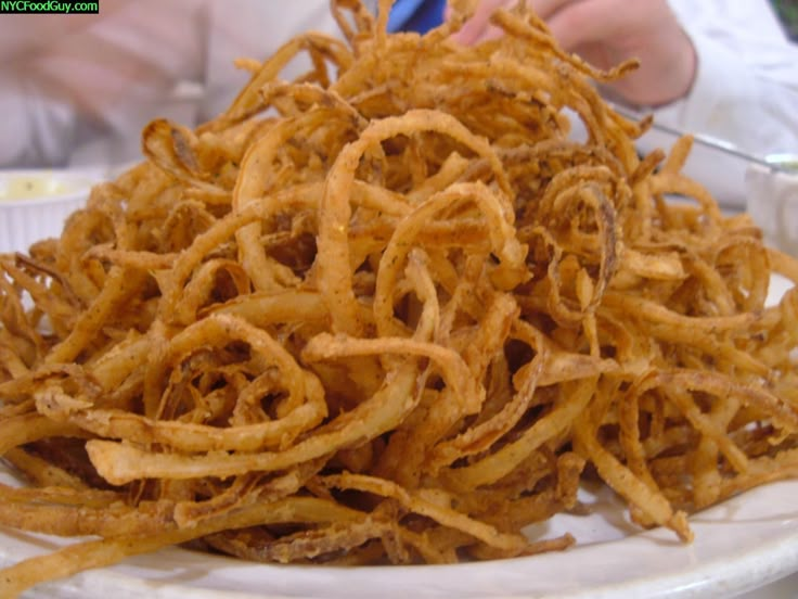 a white plate topped with fried food on top of a table