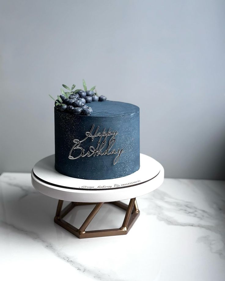 a blue birthday cake sitting on top of a white plate