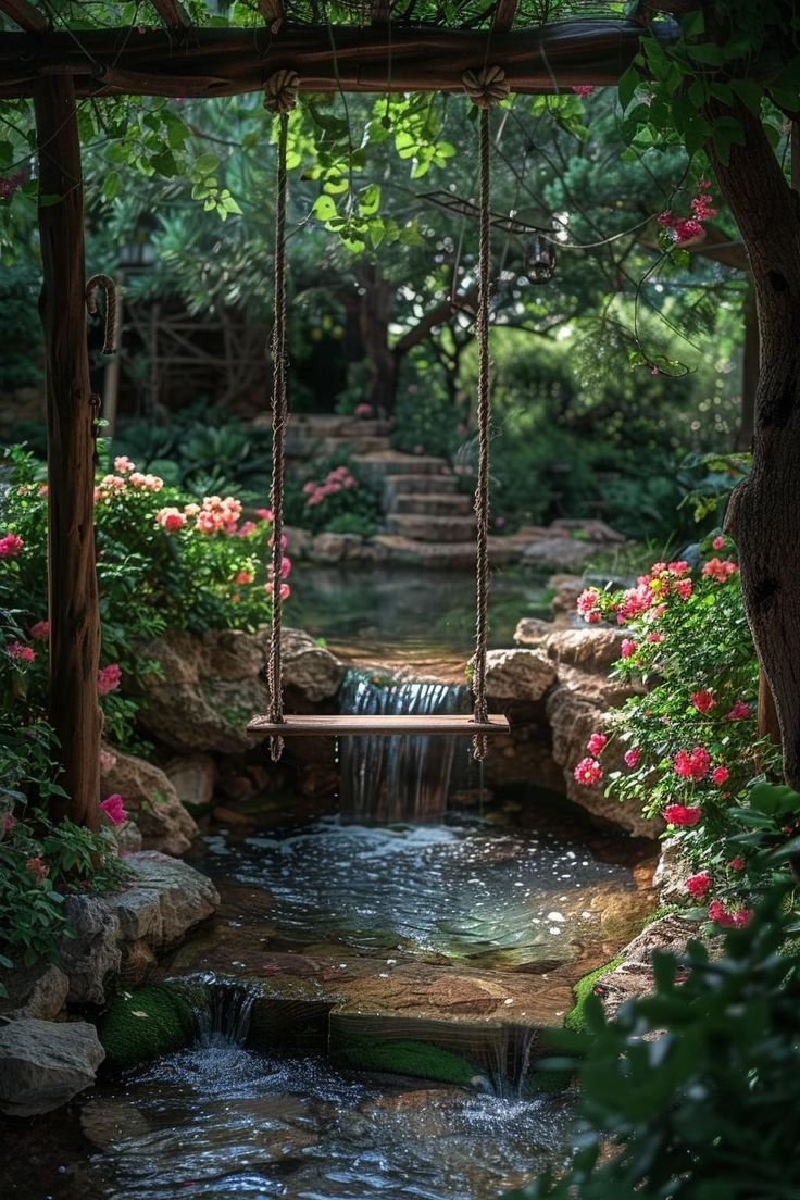 a small waterfall flowing into a pond surrounded by greenery and flowers with a swing hanging over it