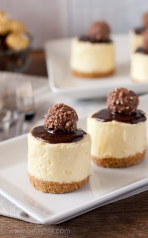 three cheesecakes with chocolate on top are sitting on a white plate and ready to be eaten