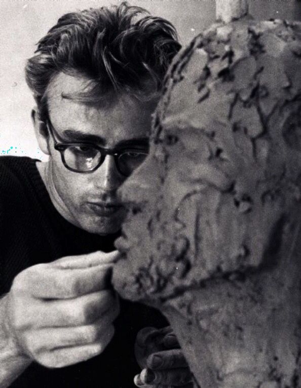 a man in glasses is working on a sculpture