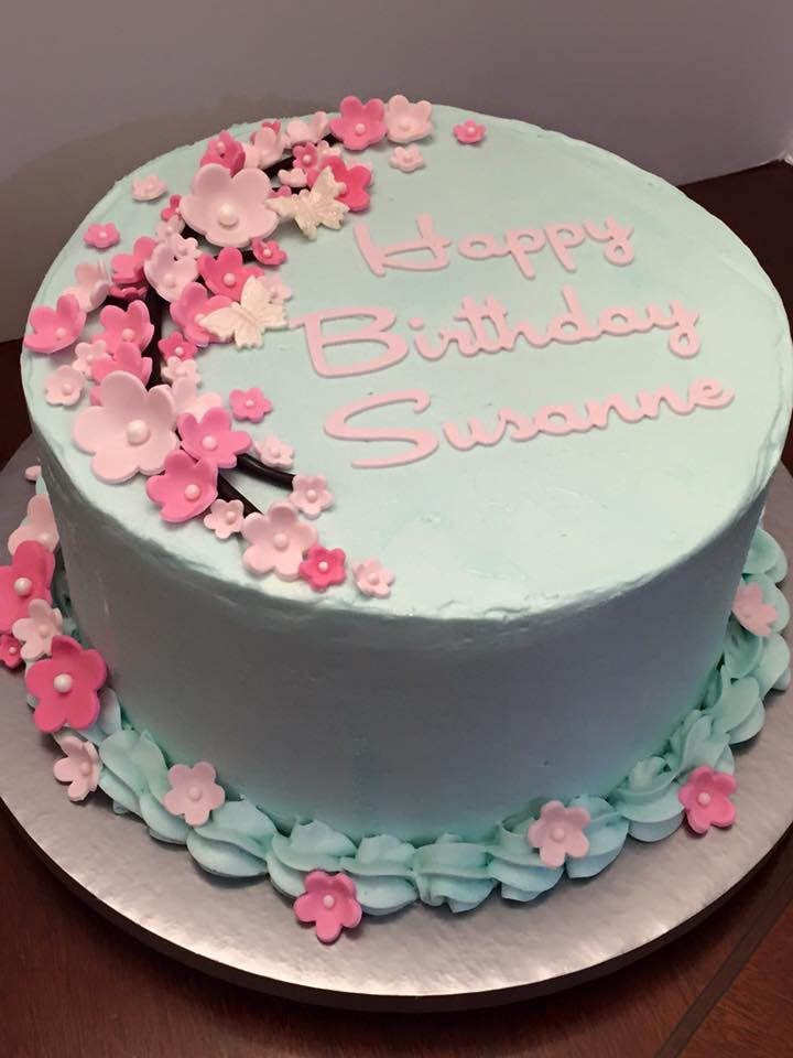 a blue birthday cake with pink flowers on it