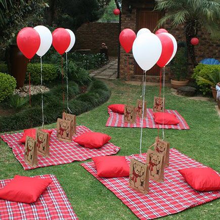 some red and white heart shaped balloons sitting on top of a checkered table cloth