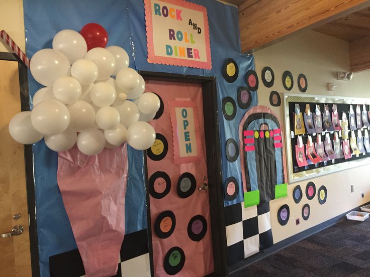 a room decorated with balloons and decorations in the shape of an ice cream shop door