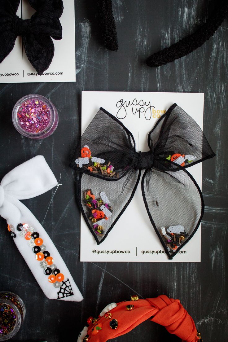 a black and white bow with candy on it sitting next to other items that include hair clips