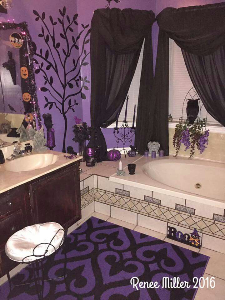 a bathroom decorated in purple and black with lots of decor on the walls, along with a large bathtub