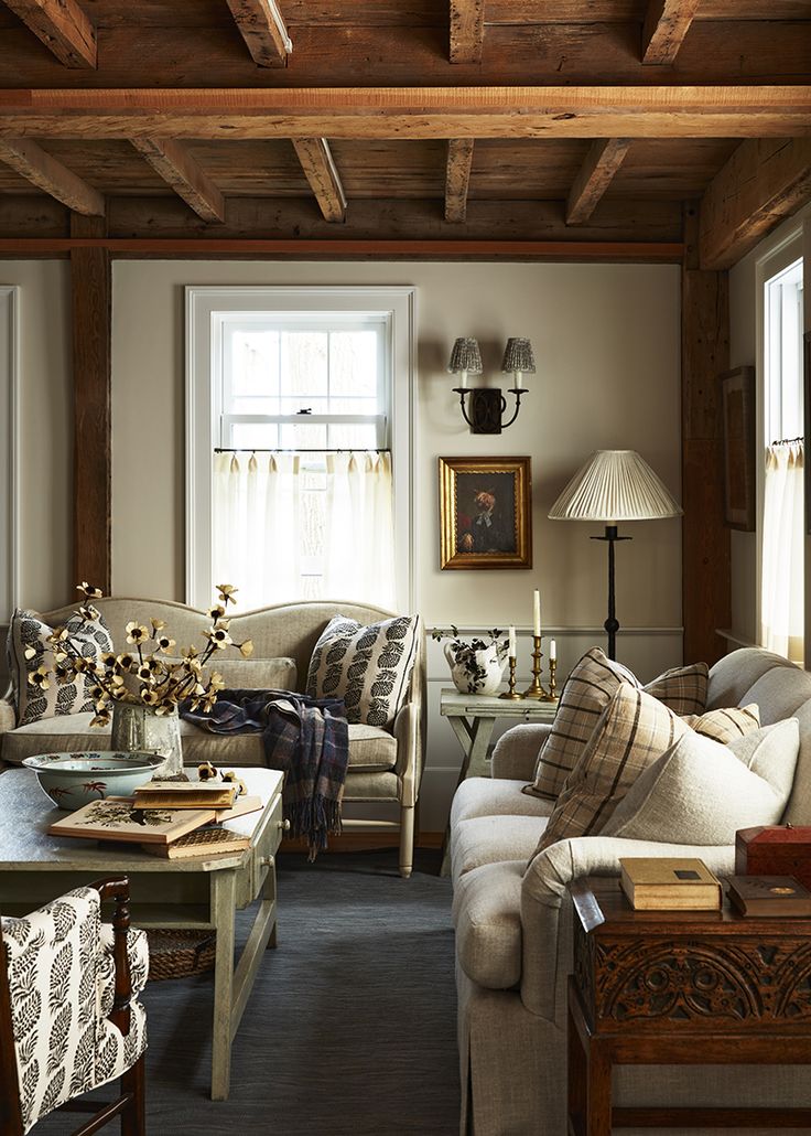 a living room with couches, tables and lamps on the side of the wall