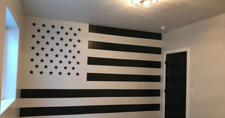 an american flag painted on the side of a wall in a room with black and white stripes