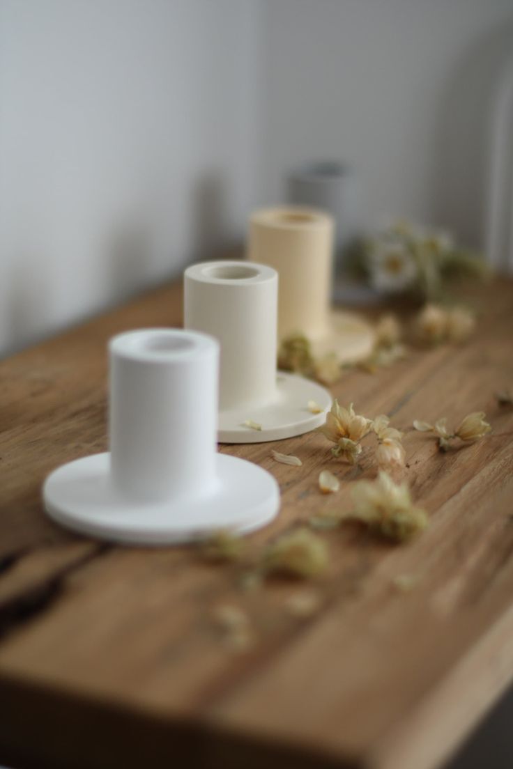 two white cups sitting on top of a wooden table