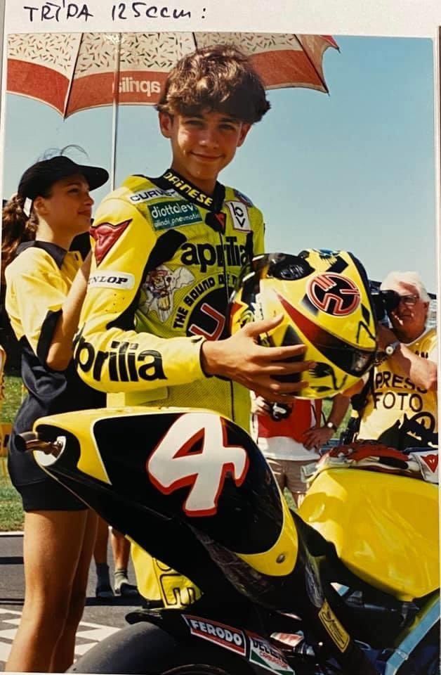 a young man sitting on top of a motorcycle next to a woman holding an umbrella