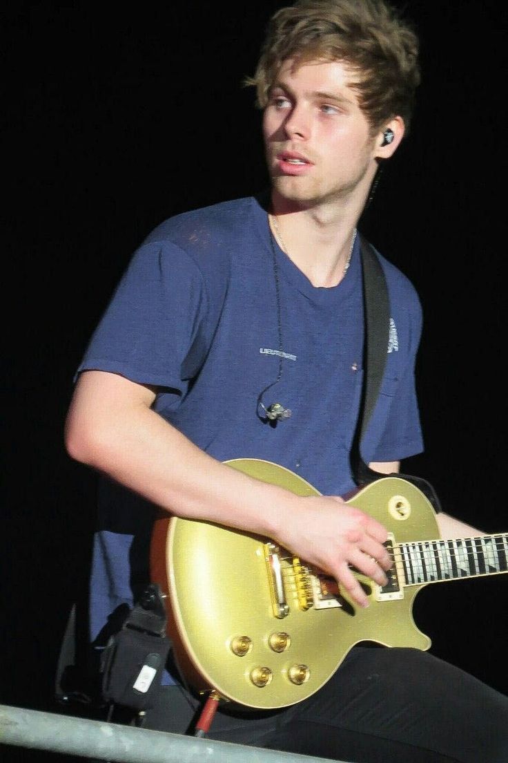 a young man playing an electric guitar on stage