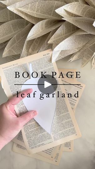 someone is holding an open book in their hand with the words book page leaf garland on it